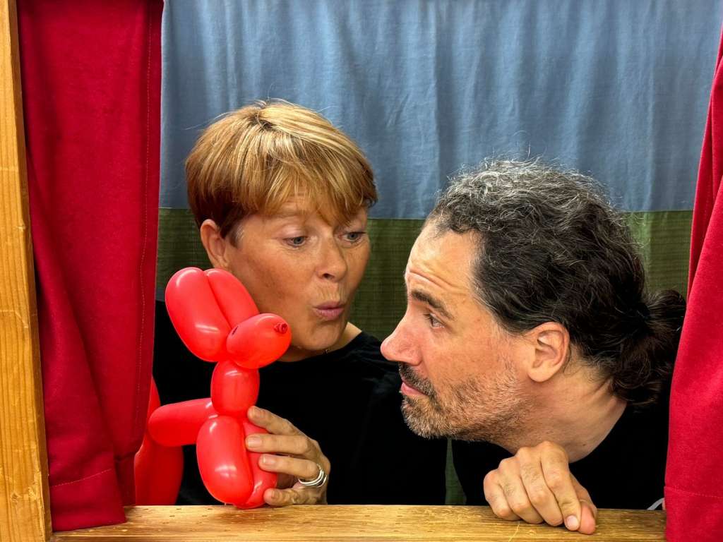 Zwei Schauspieler betrachten einen Luftballonhund